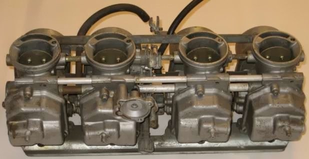 Keihin ATV carburetor assembly showing float bowls and jets for cleaning
