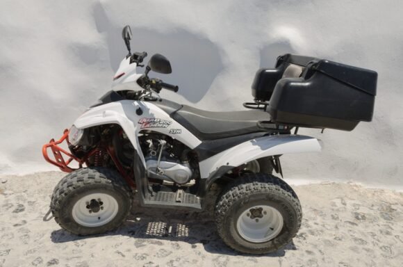 ATV utility quad parked outdoors, side profile, for a carburetor cleaning guide