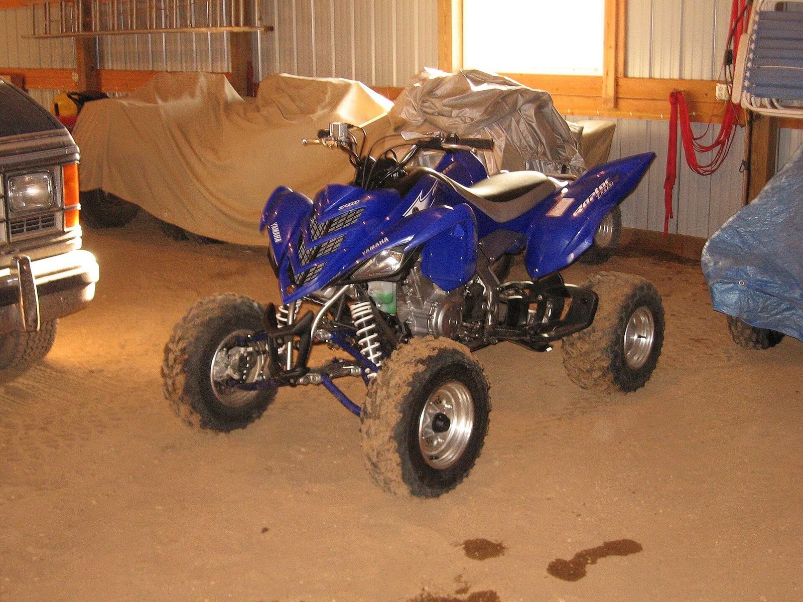 Blue Yamaha Raptor 700 sport ATV parked in a garage
