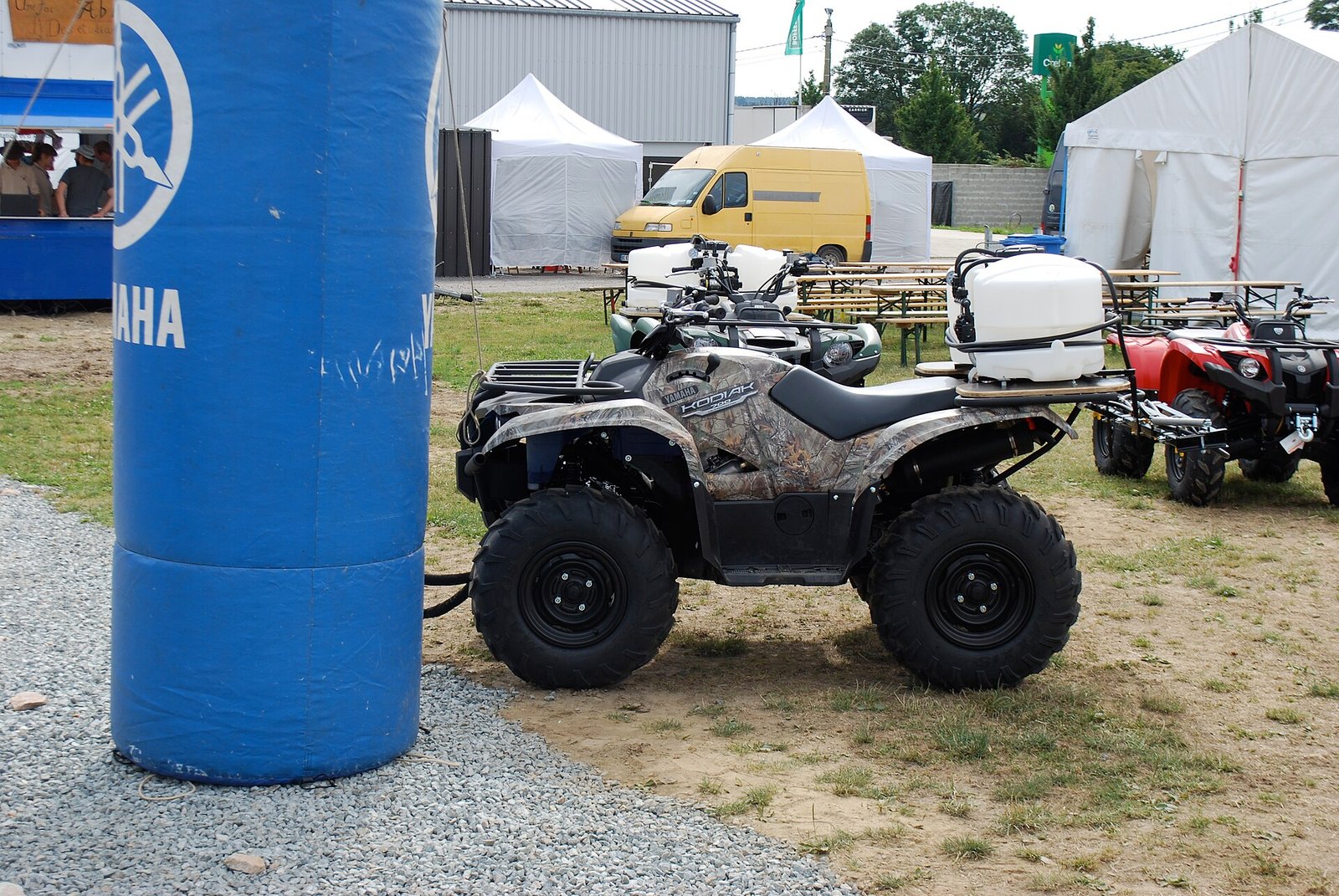 Yamaha Kodiak ATV with camouflage bodywork and black wheels at an outdoor Yamaha event