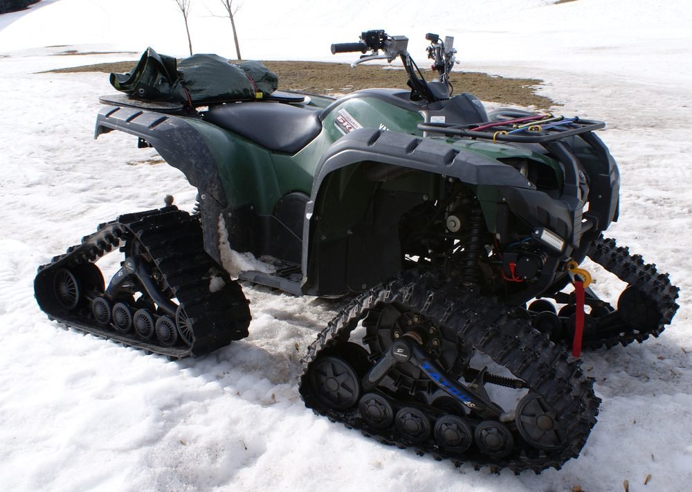 Yamaha Grizzly ATV quad in the 660 and 700 utility family, shown here with a snow track conversion on an alpine trail