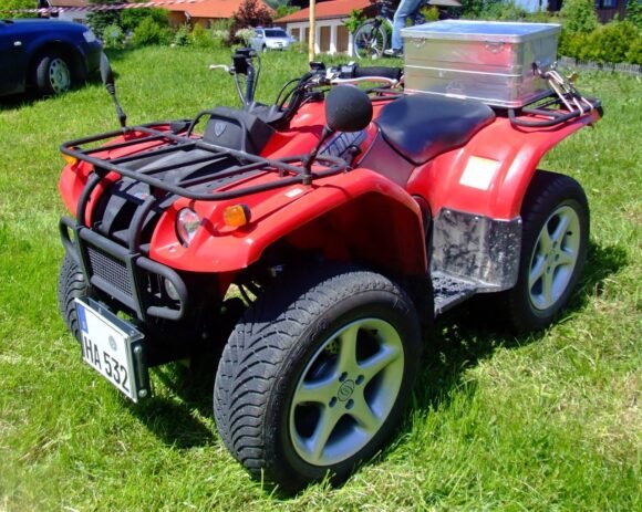 A red Yamaha Kodiak utility ATV on a lawn, the same platform family the Baja Wilderness 400 is built on